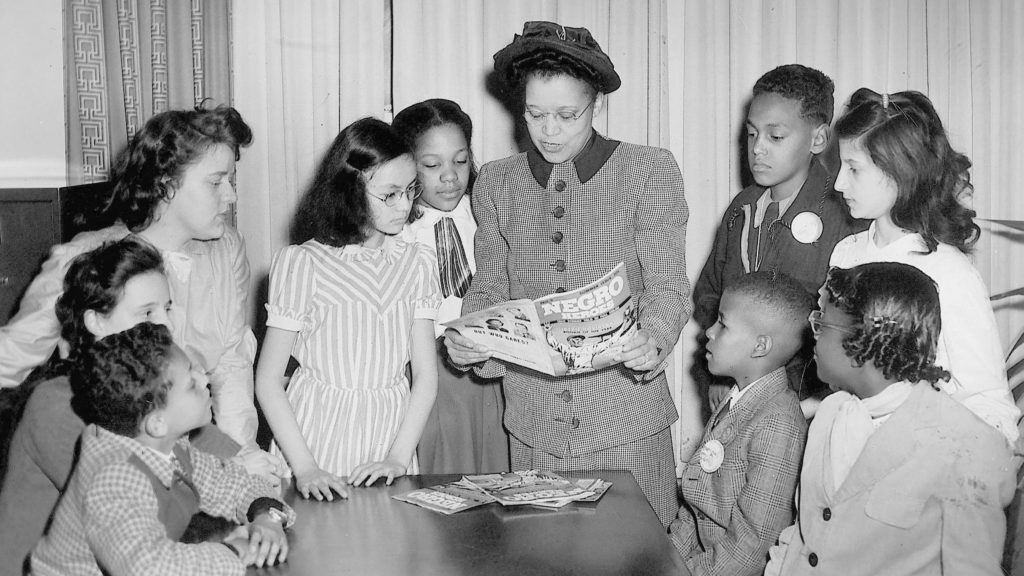 Sadie T. M. Alexander, the first African American to receive a Ph.D. in economics in the United States, reads a comic book to children in 1948. University Archives and Records Center, University of Pennsylvania.