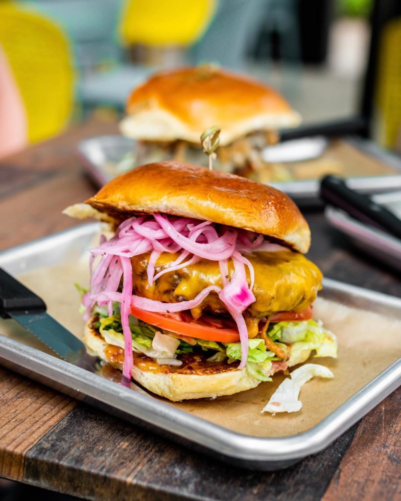 Cheeseburger with red pickled onions, tomato and lettuce from Big Buns