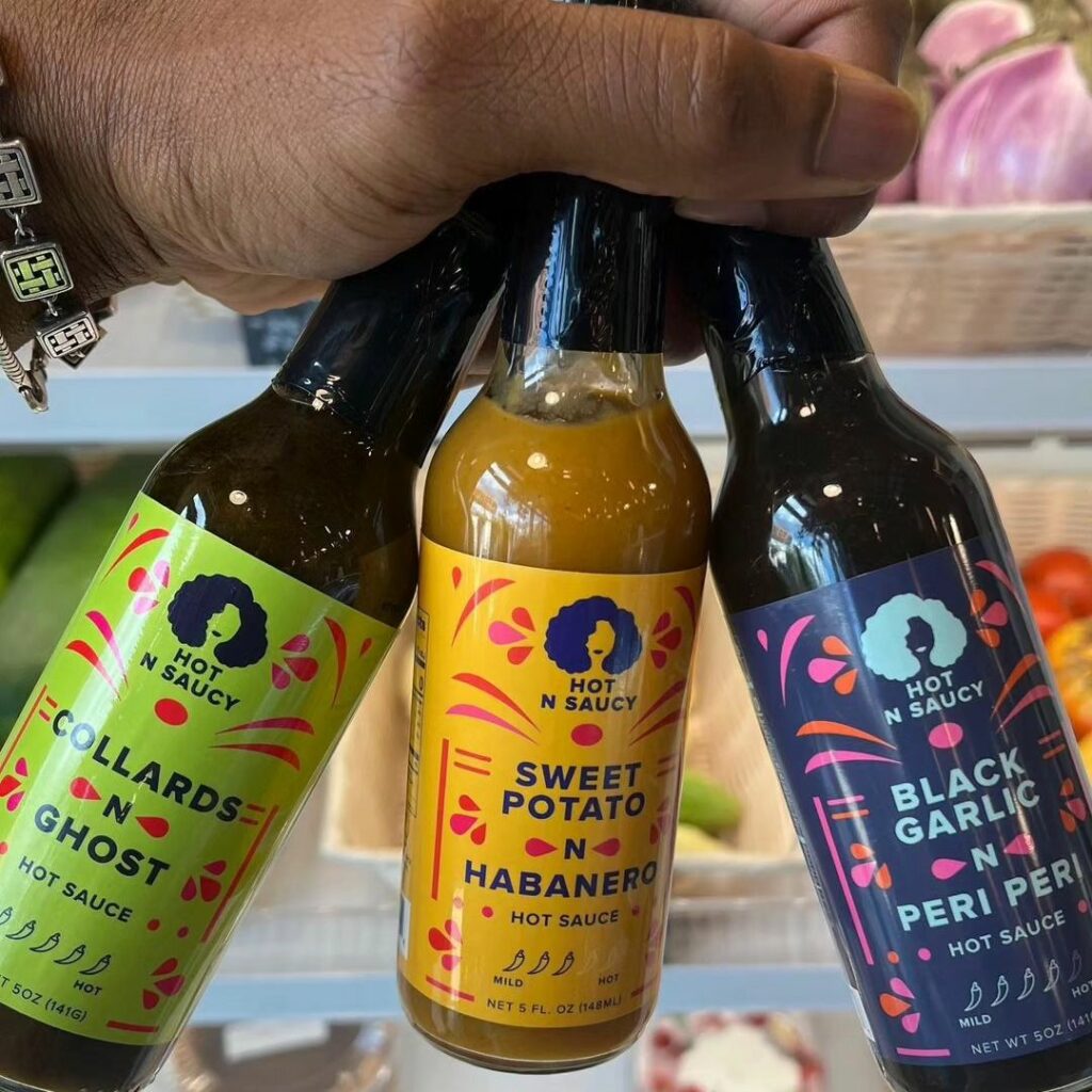 Hot n Saucy Co Hot sauce varieties being held in a hand