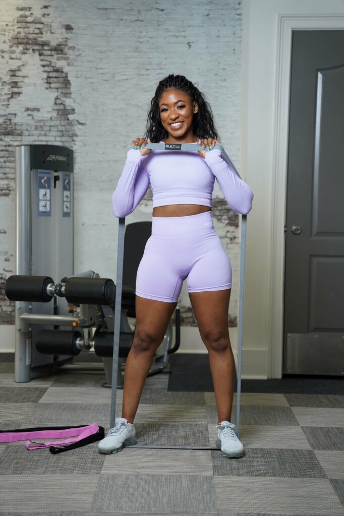 Built exclusive's owner wearing a built exclusive women's set in purple with full body resistance bands