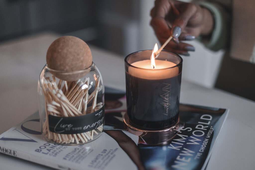 A woman lights a candle from 12th and Viv